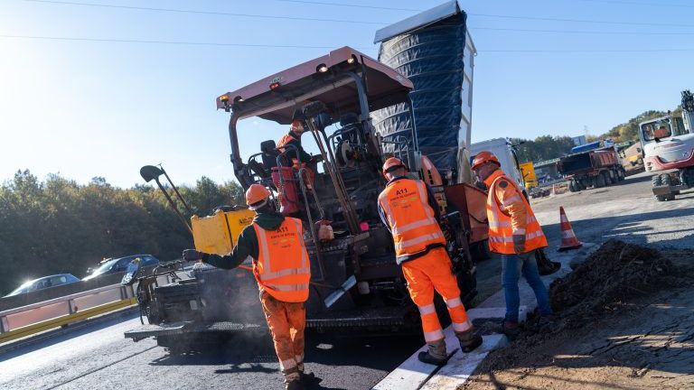 Trois personnes travaillant pour goudronner la route