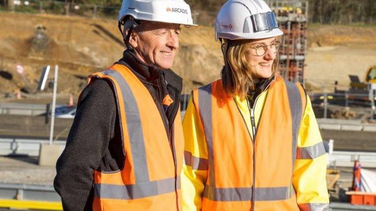 Une femme et un homme habillés avec des vestes oranges réfléchissantes et des casques